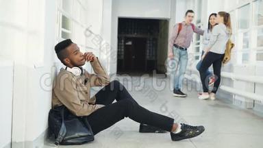 在大学走廊里坐在地板上看着不同的侧面时，令严肃的非裔美国<strong>男学生</strong>心烦意乱